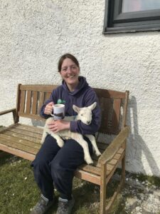 Our Ranger Hayley with a lamb on her lap and a cup of tea!